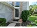 Inviting entryway with sidelight window, brick accents, and lush landscaping enhances this home's exterior at 7529 Oceanline Dr, Indianapolis, IN 46214