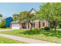 Attractive home featuring brick accents, mature trees, and a well-maintained lawn at 7742 Bayridge Dr, Indianapolis, IN 46236