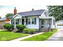 Lovely home with well-kept lawn, mature landscaping, and a quaint side porch at 907 N Arlington Ave, Indianapolis, IN 46219