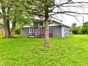 Backyard view of this single-Gathering home showing mature trees and a grassy lawn at 9080 W Forest Dr, Elwood, IN 46036