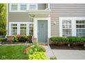 Inviting front entrance with well-maintained landscaping, complemented by a gray door and bright white trim at 9743 Herons Cv, Carmel, IN 46280