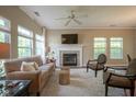Comfortable living room featuring a fireplace, large windows, and neutral decor that is ideal for relaxing and entertaining at 9743 Herons Cv, Carmel, IN 46280