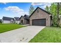 Brick home with a well-manicured lawn and a two-car garage, offering comfort and curb appeal at 9811 Warren Pl, Indianapolis, IN 46229