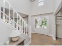 Bright foyer featuring a staircase, hardwood floors, and a view to the front yard at 10243 Brixton Ln, Fishers, IN 46037