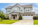 Beautiful two-story home features a gray exterior, brick accents, attached garage, and a well-maintained lawn at 10922 Liberation Trce, Noblesville, IN 46060