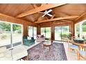 Bright sunroom features wood ceiling with exposed beams, large windows, and a ceiling fan, inviting natural light and comfort at 1102 Fox Hill Dr, Indianapolis, IN 46228