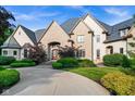 Charming front exterior featuring a stone facade, arched doorway and professional landscaping at 11101 Hawthorn Rdg, Fishers, IN 46037