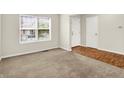 Neutral room featuring a large window, carpet, hardwood, a white door, and a white closet door at 11849 Traymoore Dr, Fishers, IN 46038