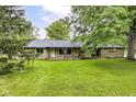 Ranch-style home features a well-maintained lawn, brick facade, and mature trees providing shade and curb appeal at 1248 Hathaway Dr, Indianapolis, IN 46229