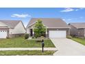Inviting exterior view of home with lawn, driveway, brick facade and neutral trim at 13321 N White Cloud Ct, Camby, IN 46113