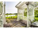 Idyllic backyard featuring a white pergola with a swing, garden, and a serene pond at 13815 Plantree Dr, Carmel, IN 46033