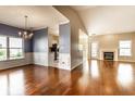Open-concept living space featuring hardwood floors, a chandelier, and a fireplace at 13815 Plantree Dr, Carmel, IN 46033