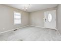 Bright living room featuring carpet and a traditional chandelier with ample natural light from a large window at 148 S 3Rd Ave, Beech Grove, IN 46107