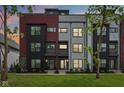 Modern townhouses with mixed brick, black, gray, and red siding under a vibrant evening sky at 1816 Rosette Way, Indianapolis, IN 46202