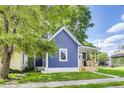 Lovely blue home with a cozy front porch and a well-maintained green lawn at 1822 Howard St, Indianapolis, IN 46221