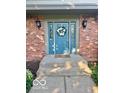 Close-up of a blue front door with sidelights and white floral wreath at 1941 Spruce Dr, Carmel, IN 46033