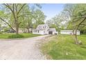 View of the front of the house, with an attached garage and a long gravel driveway at 2 S 25Th Ave, Beech Grove, IN 46107