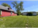 Expansive backyard with a red home, a detached garage, and lush green grass at 2115 S I St, Elwood, IN 46036