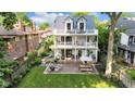 Charming three-story house with multiple balconies, a brick patio with seating, and a spacious lawn at 3215 N Pennsylvania St, Indianapolis, IN 46205
