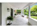 Spacious front porch with concrete floor, white columns and ceiling, and a comfortable hanging daybed at 3215 N Pennsylvania St, Indianapolis, IN 46205