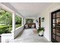 Inviting covered front porch with concrete flooring, classic columns, and outdoor seating with a cozy ambiance at 3215 N Pennsylvania St, Indianapolis, IN 46205