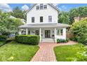 Inviting two-story white home with a charming front porch and well-manicured lawn and shrubs at 3215 N Pennsylvania St, Indianapolis, IN 46205