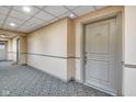 Hallway view of the entry door to unit A303 with neutral-toned walls and patterned carpeting at 350 N Meridian St # A303, Indianapolis, IN 46204