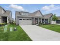 A charming gray home with a well-manicured lawn, a two-car garage, and a welcoming front porch at 395 Ehrlich Ln, Westfield, IN 46074