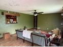 Spacious living room with wood-look flooring, ceiling fan, and a large window providing ample natural light at 409 W 3Rd St, Alexandria, IN 46001