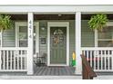 Close-up of a charming front porch with potted plants and a decorated front door at 4414 Winthrop Ave, Indianapolis, IN 46205