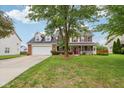 Beautiful home with a lush green lawn and mature trees, showcasing curb appeal at 4434 W Windsong Ct, New Palestine, IN 46163