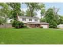 Traditional two-story home featuring a brick facade, white siding and lush green lawn at 4840 E 77Th St, Indianapolis, IN 46250