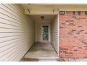 Covered entry featuring brick accents, cream-colored siding, and a glass-paned front door at 6010 Rocky River Dr, Indianapolis, IN 46221