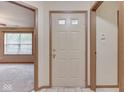 The front door opens to neutral-colored walls, trim, and carpeted floors, adjacent to a large living area at 6010 Rocky River Dr, Indianapolis, IN 46221