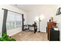 Well-lit bedroom with plush carpet, large window with blinds, and modern furniture arrangement at 6556 Sulgrove Pl, Indianapolis, IN 46221
