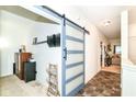 Hallway featuring a sliding barn door, functional storage, and a view into the living area at 6556 Sulgrove Pl, Indianapolis, IN 46221
