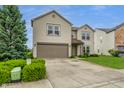 A view of a two-story home with a two-car garage, surrounded by lush green landscaping at 8088 Lantern Ln, Pendleton, IN 46064