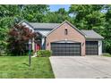 Charming two-story home showcasing a brick facade, two-car garage, and a well-manicured front lawn at 8530 Ardennes Dr, Fishers, IN 46038