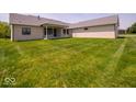 Expansive backyard features lush green grass and a covered patio at 10586 Jacks Way, Indianapolis, IN 46234