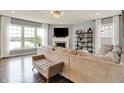 Bright living room with large windows, a fireplace, hardwood floors, and comfortable seating at 1071 Serenity Ct, Carmel, IN 46280