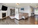 Open living room with a fireplace, hardwood floors, and neutral decor at 1071 Serenity Ct, Carmel, IN 46280