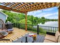 Relaxing patio with a grill, water view, string lights, and comfortable outdoor furniture at 1071 Serenity Ct, Carmel, IN 46280