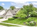 Attractive home featuring a lush lawn, mature trees, and a well-kept garden at 10888 Weston Dr, Carmel, IN 46032