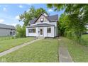 Charming two-story home with black roof, white siding and inviting front yard with green grass at 1150 W 30Th St, Indianapolis, IN 46208