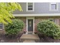 Welcoming front door with brick facade and manicured shrubs, creating an inviting entry to the home at 11807 Rolling Springs Dr, Carmel, IN 46033
