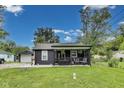 Inviting home with a covered front porch, mature trees, and a well-maintained lawn at 1617 S Whittier Pl, Indianapolis, IN 46203