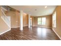 Bright living room with staircase, wood floors, and view to the front yard from large windows at 16247 Countryside Blvd, Westfield, IN 46074