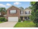Lovely two-story home with brick and siding, featuring a two-car garage and cozy front porch with chairs at 16732 Maraschino Dr, Noblesville, IN 46062