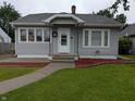 Inviting home exterior with gray siding, green lawn, and a welcoming front porch with a wreath at 1728 Newton St, Columbus, IN 47201