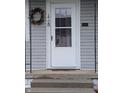 Close-up of a front door with glass panel, decorative wreath, and a mail slot at 1728 Newton St, Columbus, IN 47201